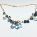 Collar or topaç blau i cianita gotes d'aigua